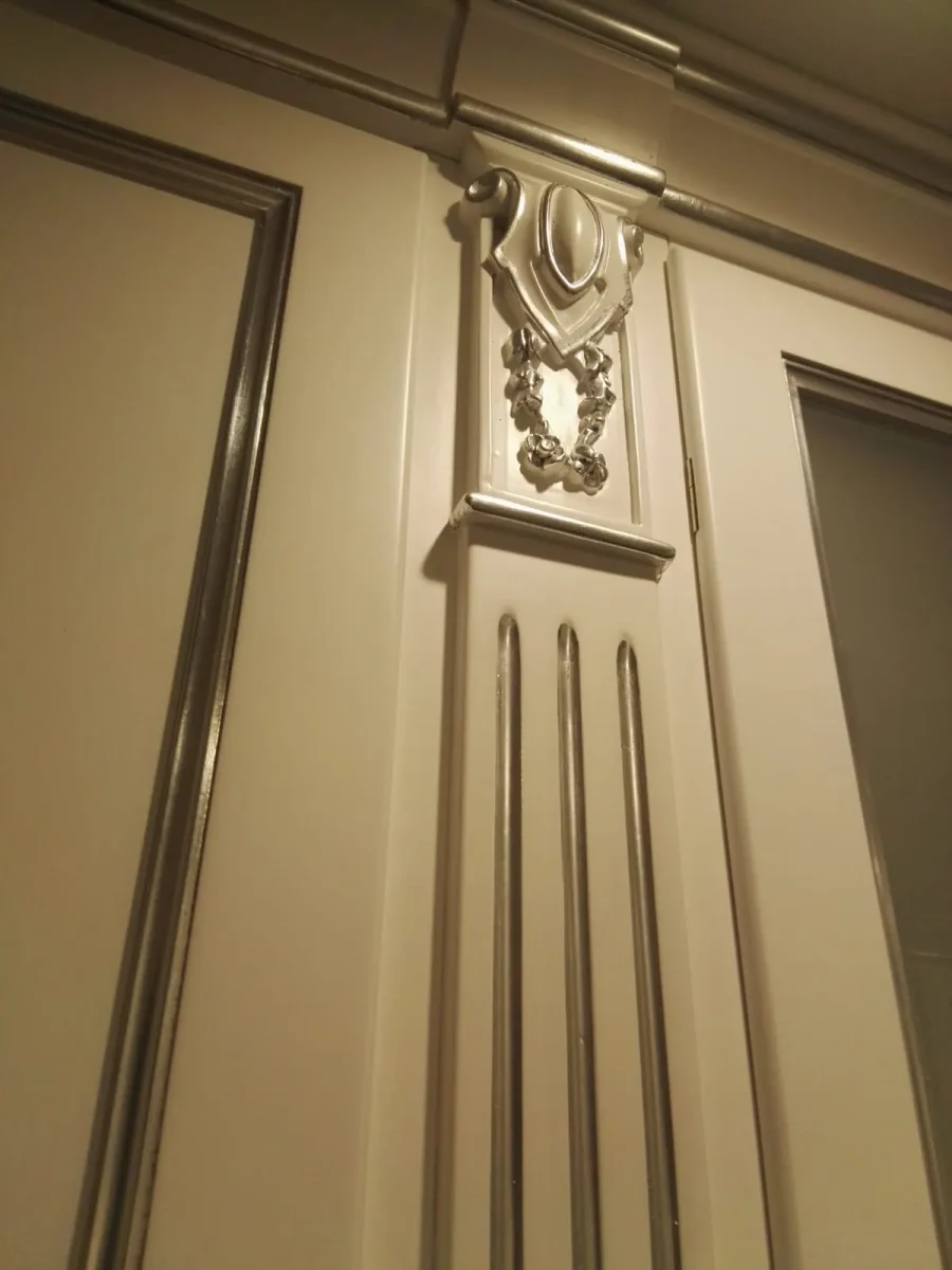 Dettaglio di mensola con cornice intagliata e profilo metallico