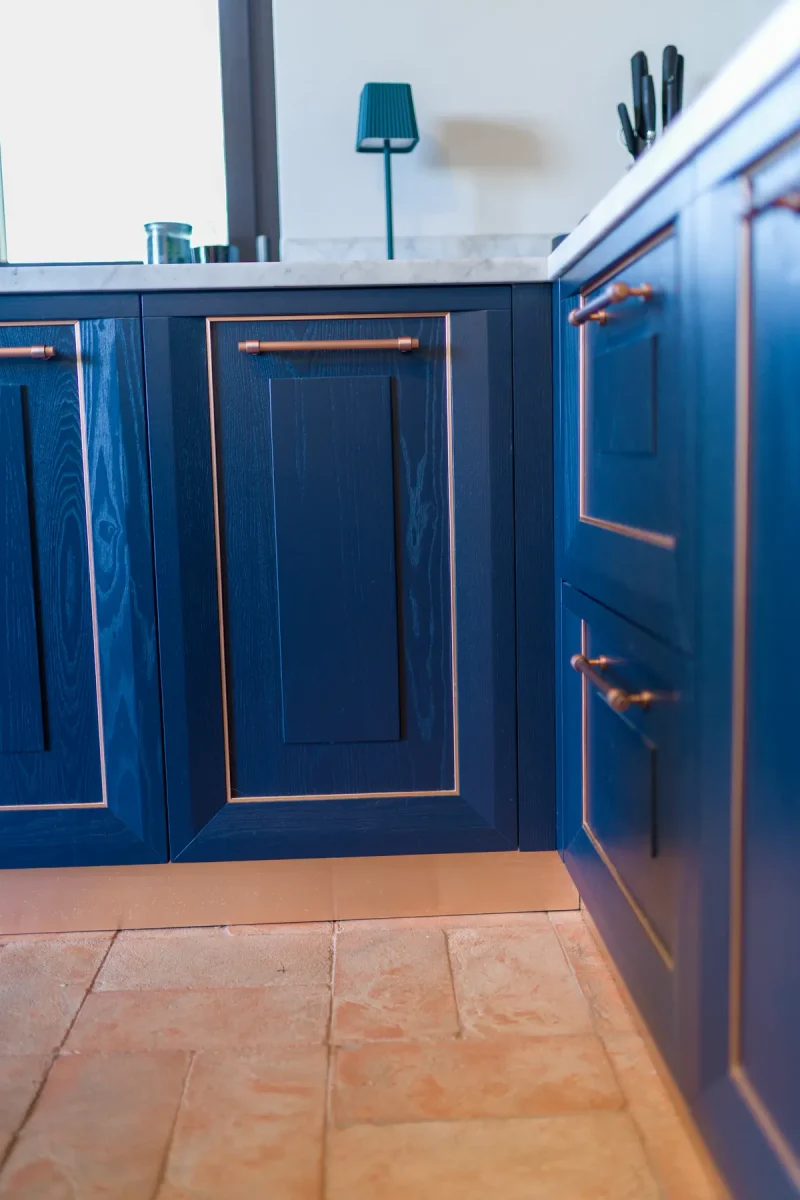 Basi in rovere laccato blu con zoccolo metallico, sopra il pavimento in cotto fatto a mano