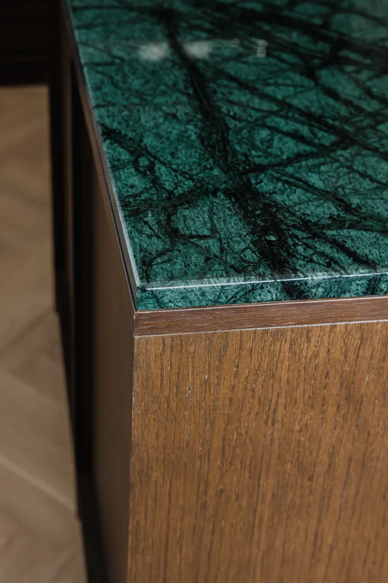 Angolo del piano in marmo verde alpi con vene bianche, a filo del fianco in legno wengè.